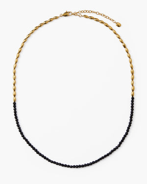 Gold beaded necklace with black gemstone beads and lobster clasp on white background