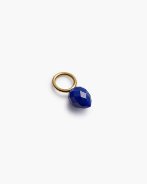 Gold hoop with blue gemstone charm on a white background
