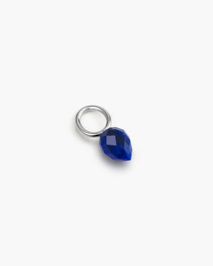 Silver hoop with blue gemstone charm on a white background