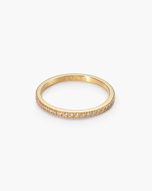Gold white sapphire eternity ring on a white background