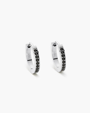 Pair of silver hoop earrings lined with black gemstones and engraved lettering, shown on a white background.