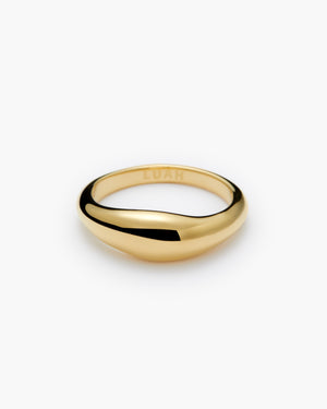 Gold dome ring with a subtle wave-shaped twist, engraved "LUAH" on the interior band, shown on a white background