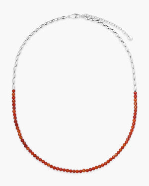 Red gemstone beaded necklace with silver oval accent beads on a white background