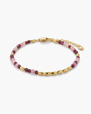 Gold beaded bracelet with pink and burgundy stone accents on white background