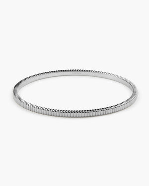 Silver ribbed textured bangle bracelet, engraved with a brand logo, photographed on a plain white background.