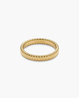 Gold ribbed textured ring, engraved with a brand logo on the inner band, photographed on a plain white background.