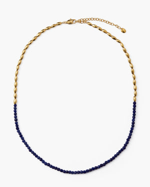 Blue gemstone beaded necklace with gold oval accent beads on a white background