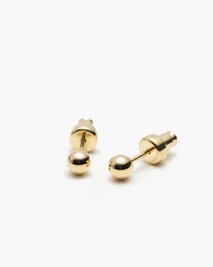 Pair of small gold ball stud earrings with screw-back closures, laid on a white background.