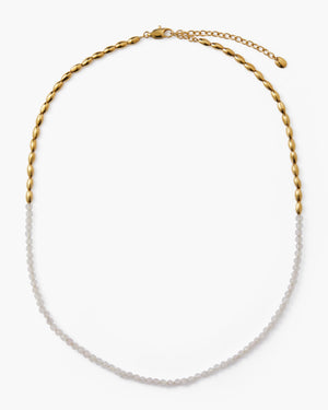 White gemstone beaded necklace with gold oval accent beads on a white background
