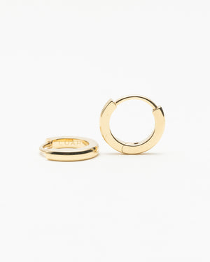 Pair of small gold hoop earrings with engraved lettering on the inside, shown on a white background