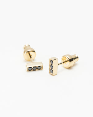 Pair of gold bar stud earrings, each set with three black gemstones